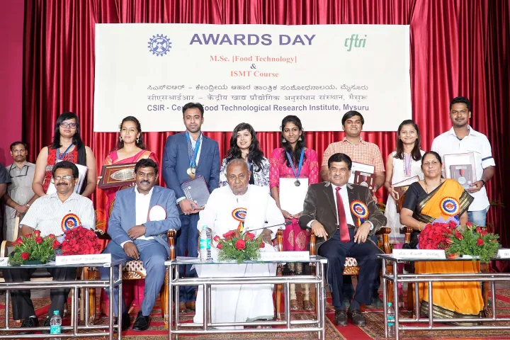 Awards Day for M.Sc. Food Technology and ISMT: award-winning students standing behind seated dignitaries on stage
